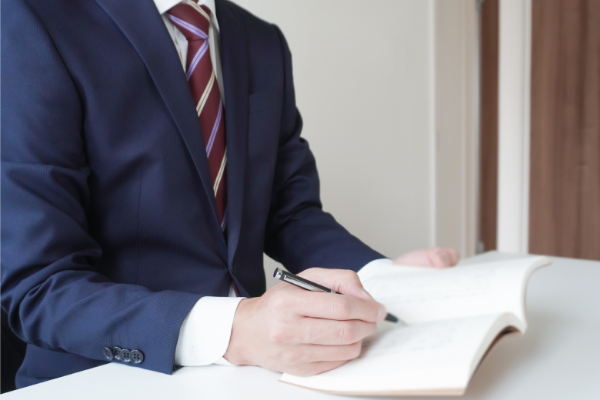 手帳に書き込む男性